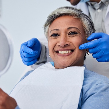 smiling patient holding a mirror 