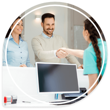 Man shaking hands with dental team member at front desk