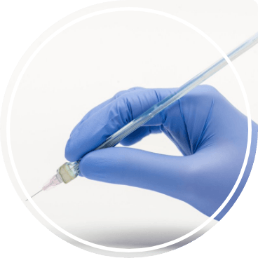 Gloved hand holding an extremely thin syringe