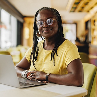 Woman in yellow shirt smiling while working