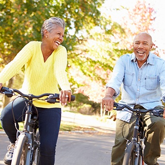Couple smiling while riding bikes outside