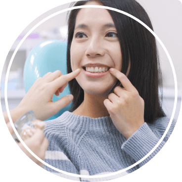 Dental patient pointing to her smile