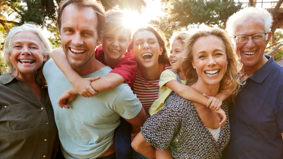 Three generations of family laughing outdoors after visiting Winchendon dentist