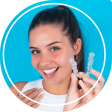 Smiling young woman holding Invisalign clear aligner
