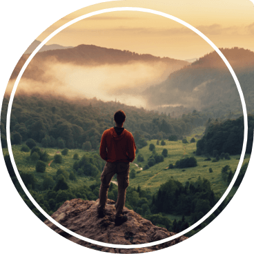 Person standing atop mountain admiring the view