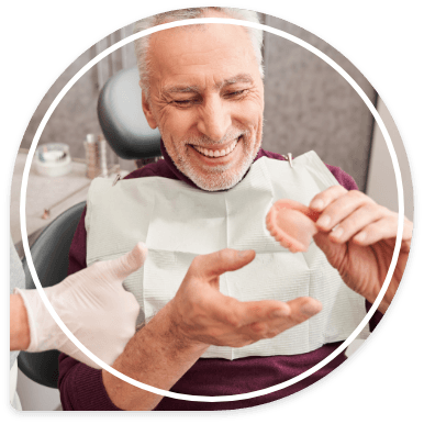 Smiling senior man receiving a full denture from his dentist