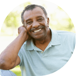 Man in light green polo shirt grinning outdoors