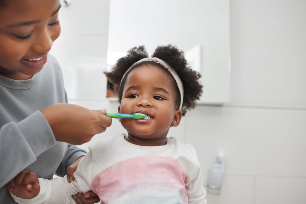 Woman brushing her toddler's teeth